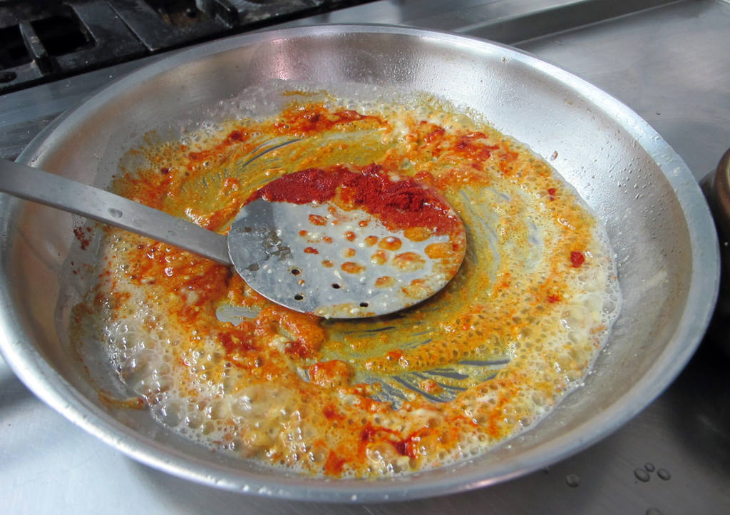 Del aceite resultante en sartén, se añade una cucharada de harina, el ajo picado y la almendra. Remover hasta que se cuaje la mezcla. Añadir el pimentón y remover.