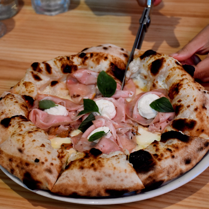 Vinos italianos y postres caseros   La carta se acompaña con una selección de vinos italianos que no busca alardes, sino afinidad con la masa, la acidez del tomate, los quesos y embutidos napolitanos. Es una elección pensada para acompañar a cada uno de los bocados.   El cierre se sostiene con postres italianos elaborados en casa: tiramisú con buena estructura, babà con pistacho, coulant de chocolate para quienes buscan algo más inmediato. Sobremesa de trattoria, sin prisa.   Un italiano para quienes buscan