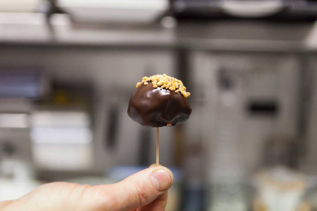 Introducir un palillo en la bola de foie congelada y sumergirla en el chocolate caliente. Antes de que el chocolate se endurezca, mojar la bola con un poco de almendra en granillo.