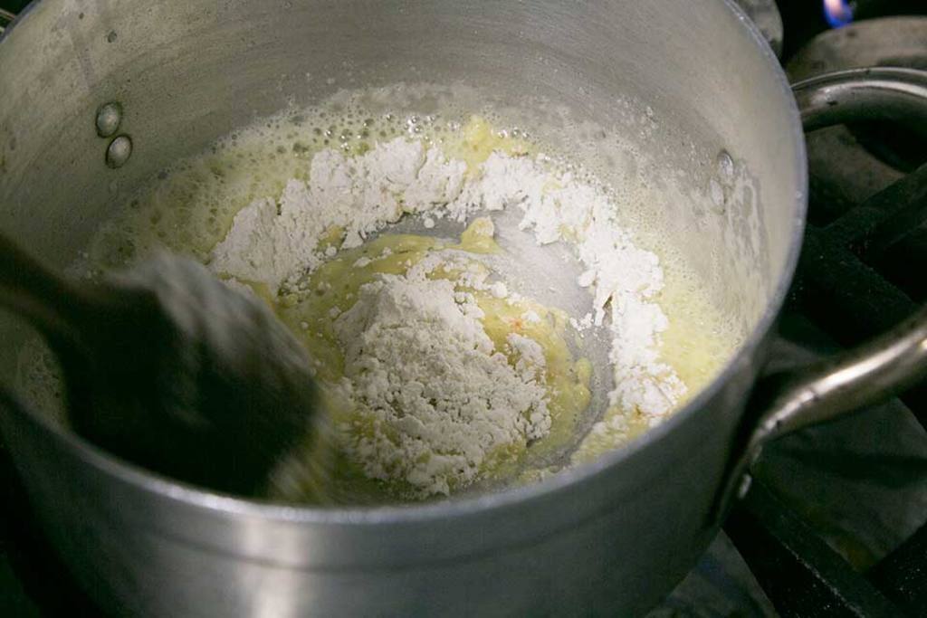 Preparamos la bechamel poniendo la mantequilla en una cazuela al fuego y, cuando se derrite, añadimos la harina. Dejamos enfriar hasta que aparezcan burbujitas. 