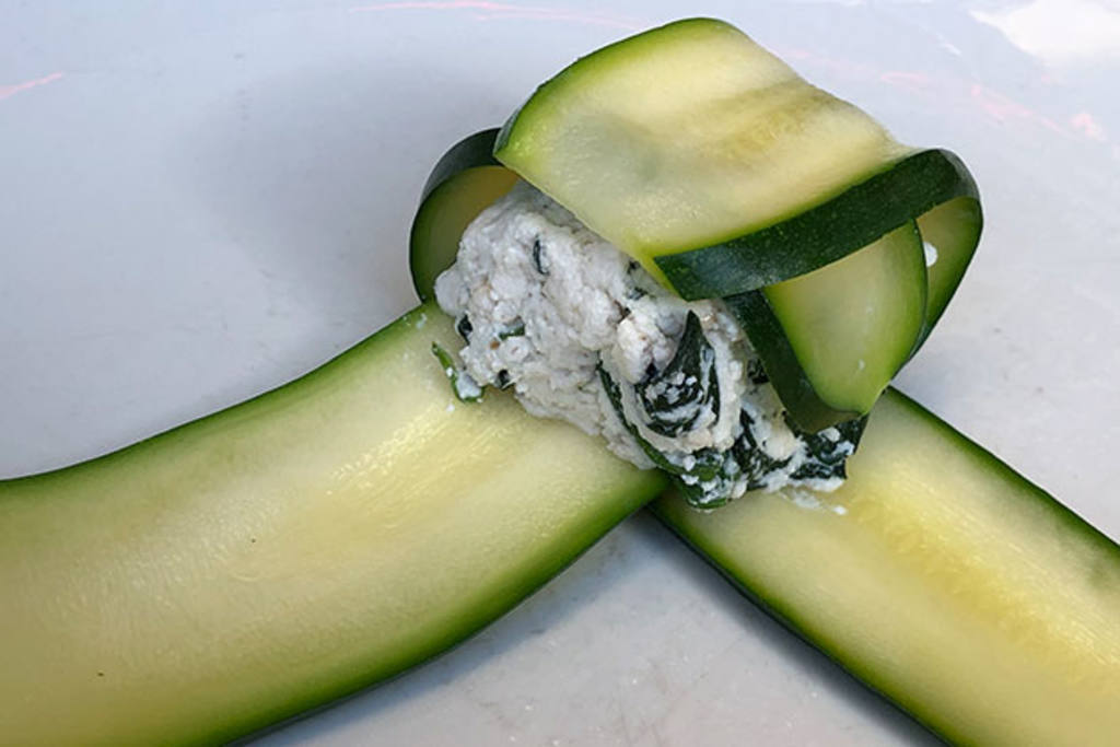 Raviolis de calabacín rellenos de queso fresco, nueces y espinacas con brotes y flores 
