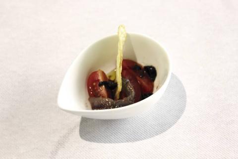 Ensalada de tomate y anchoa con vinagreta de ajo negro sobre base de chip picante