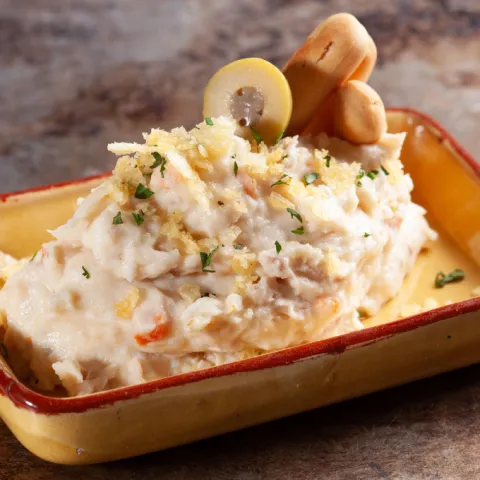 Nuestra ensaladilla rusa con patata, huevo, atún, aceituna, zanahoria y mayonesa con picos de pan y crujiente de patata chip.