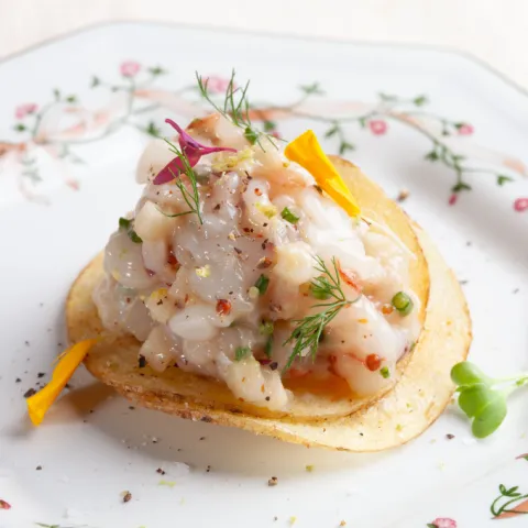 Tartar de gambas con salicornia y mayonesa de carbón sobre patata chip casera.