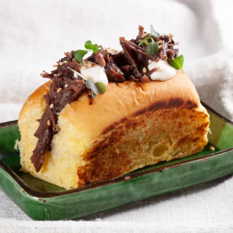Brioche tierno relleno de meloso de ternera cocinado a fuego lento y desmenuzado con semillas de sésamo.
