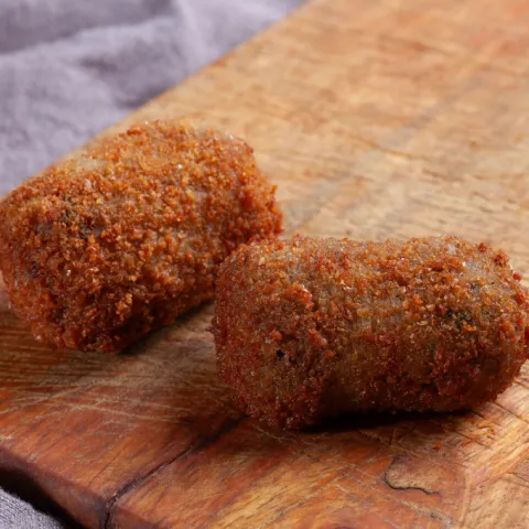 Una croqueta de carrillera ibérica y otra de berenjena con queso de cabra.