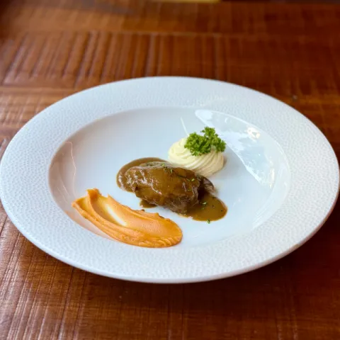 Carrillera al vino tinto con toques de cacao, canela y naranja acompañada con parmentier de patata y cremoso de boniato