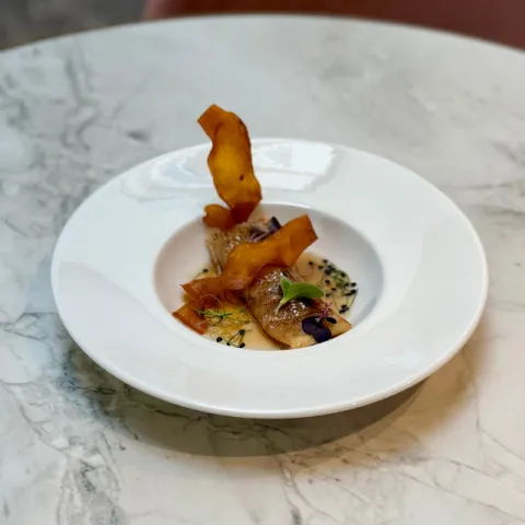 Caramelo relleno de secreto ibérico, salseado con reducción de oloroso y acompañado de crujiente de boniato