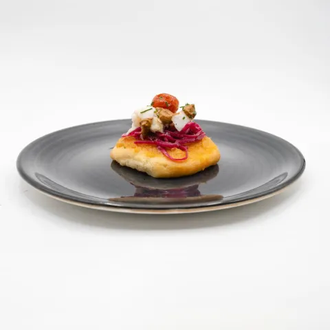 Salaílla con crema de orejones, chucrut de lombarda, tartar de bacalao confitado, pesto de aceitunas negras y cherry confitado