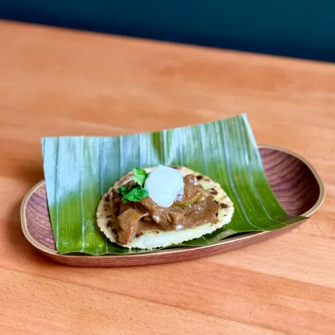 Teja de maíz cubierta con lagartito ibérico en curry de chocolate negro y alioli de coco