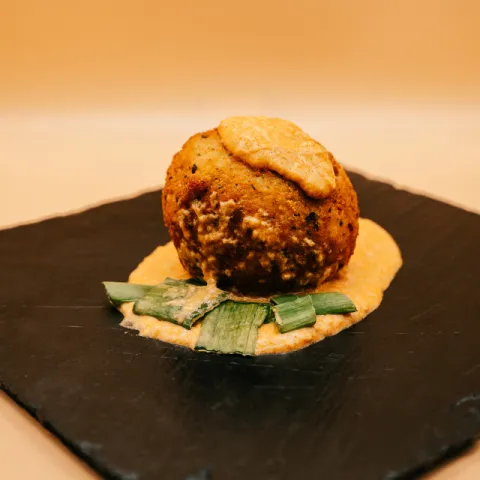 Bola de puré de patatas rellena de pollo con especias africanas y el toque especial de la casa. 