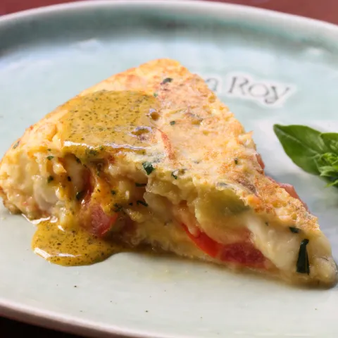 Tortilla de patatas con cebolla, tomate natural, mozzarella, albahaca fresca y pesto ligero de tomate