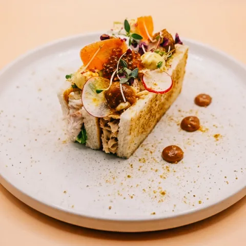 Bikini mar y montaña de cangrejo y pollo asado, verduritas en láminas,  esferas de soja, gel de cebolla caramelizada y especias africanas.