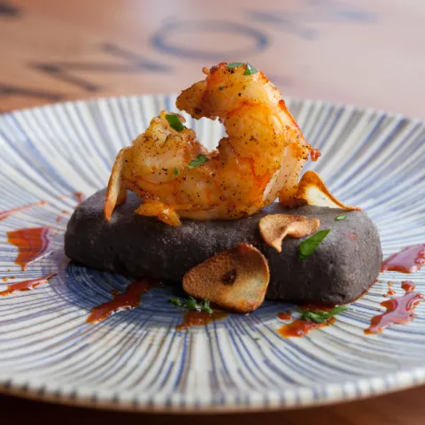 Parmentier de patata trufada con morcilla negra y salteado de gambitas al ajillo