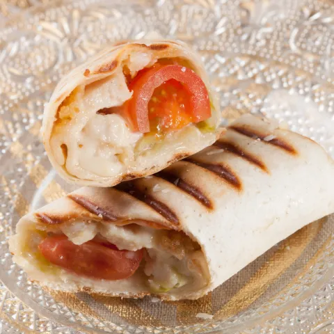 Wrap de lechuga relleno de tomates cherry, pechuga de pollo empanada y nuestra salsa César.