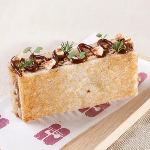 Bikini tostado con mantequilla relleno de pollo asado desmenuzado y queso emmental.