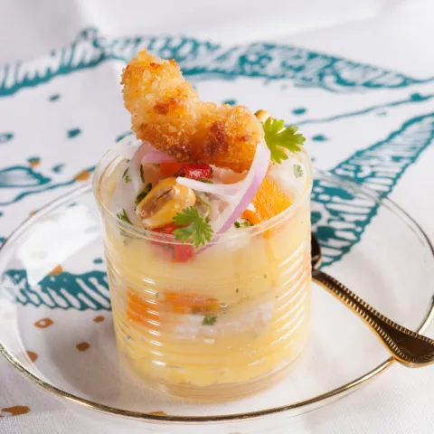 Pescado blanco marinado con lima sobre causa de patata, con cebolla, ají limo peruano semipicante y gambas rebozadas con panko.