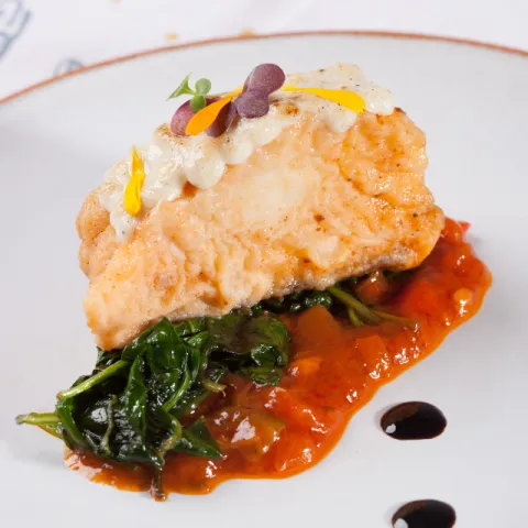 Bacalao confitado con sofrito a la catalana, espinacas y muselina suave de ajo.