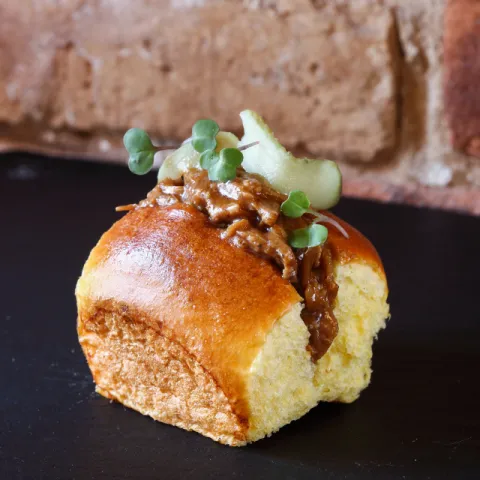Pan brioche con pulled pork, salsa chipotle y brotes de rábano picante