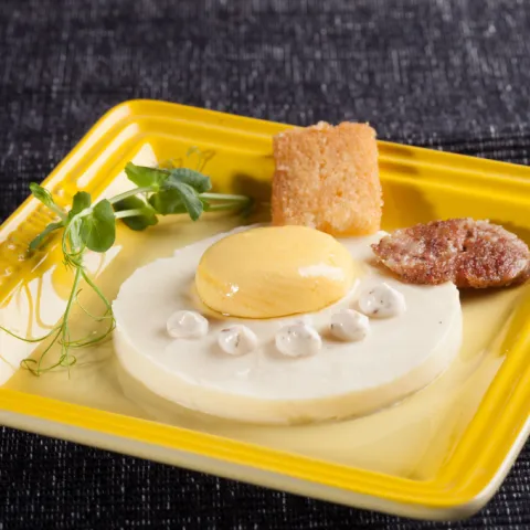 Esferificació de formatge d'ovella curat i taronja sobre puré de patata infusionat amb botifarra, coronada amb maionesa trufada i acompanyada de pa i cruixent de botifarra del perol.