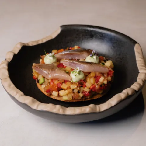 Coca de xeixa (trigo candeal), brunoise de tombet, sardina ahumada y alioli de hierbabuena