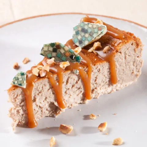 Tarta de queso cremosa con avellanas locales tostadas y un mosaico de chocolate blanco de colores.