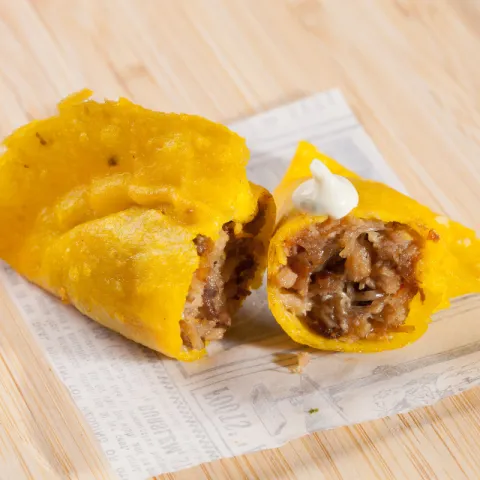 Empanadilla rellena de cerdo guisado con salsa de ajo.