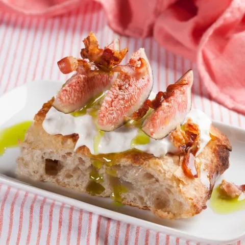 Focaccia amb stracciatella, figues, emulsió de les seves fulles i guanciale cruixent.