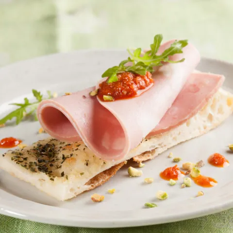Focaccia cruixent amb mortadel·la italiana, festucs, pesto rosso i ruca.