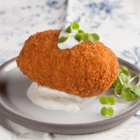 Croquetón de pollo al curry con salsa de yogur cítrica y eneldo.