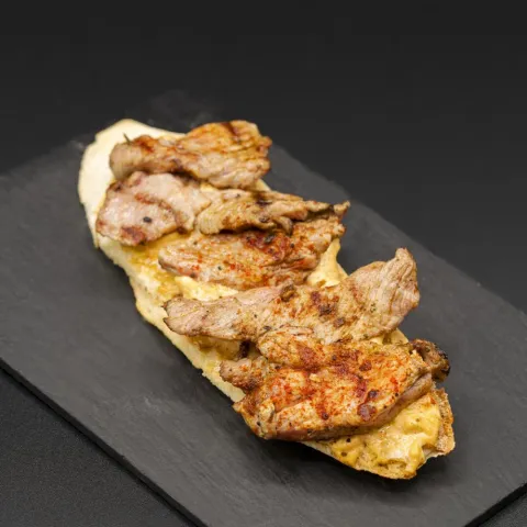 Tosta de solomillo de cerdo marinado a la brasa con base de alioli