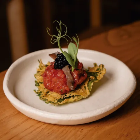 Steak tartar sobre shiso crujiente, anchoas del Cantábrico y huevas ahumadas