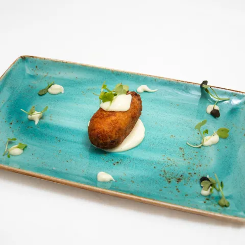 Croqueta de pulpo asado sobre cremoso de patata