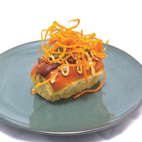 Pan brioche con costillar bbq desmechado, cebolla frita, pepinillos, salsa gaucha y chips de boniato