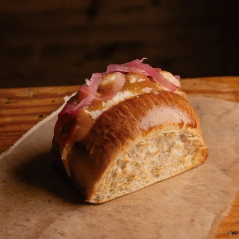 Pan de brioche relleno de ensaladilla de patata y encurtidos al estilo japonés, con gambas al ajillo flambeadas con sake
