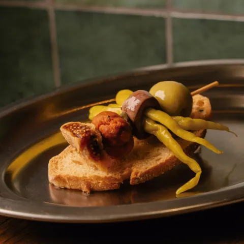 Gilda d'oliva grossal i piparres amb anxova del Cantàbric, sobrassada IGP Mallorca i figa seca, sobre torrat cruixent