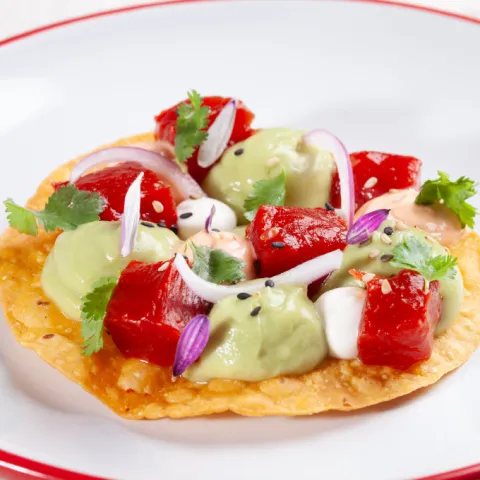 Base crujiente de maíz tostado, coronada con dados marinados en tamari, cremoso de aguacate y un toque atrevido de chili garlic mayo.
