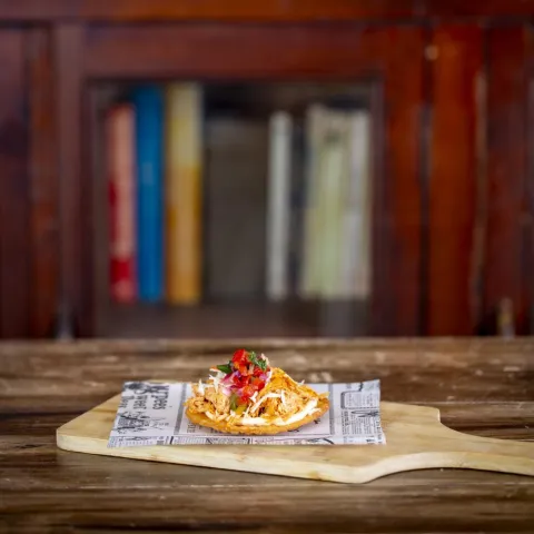 Tosta crujiente con topping de tinga de pollo y parmesano