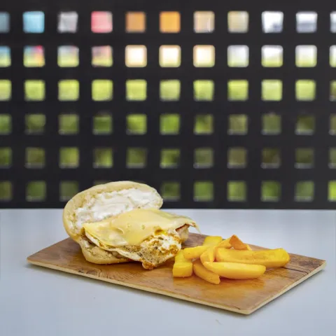 Bollo con lomo, huevo, queso y alioli acompañado con patatas fritas