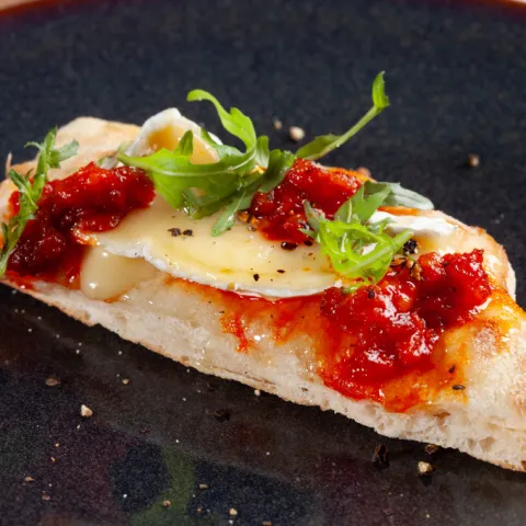 Focaccia con queso brie, sobrasada, rúcula y un toque de miel.