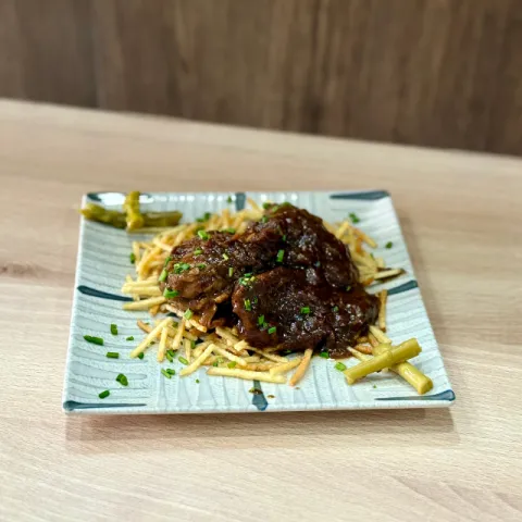 Carrillada ibérica en su salsa sobre base de patata paja