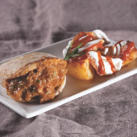 Mini pan de pita relleno de carne de cerdo con salsa
