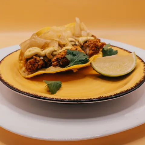 Taco de pollo crujiente con salsa africana  y ensalada. 