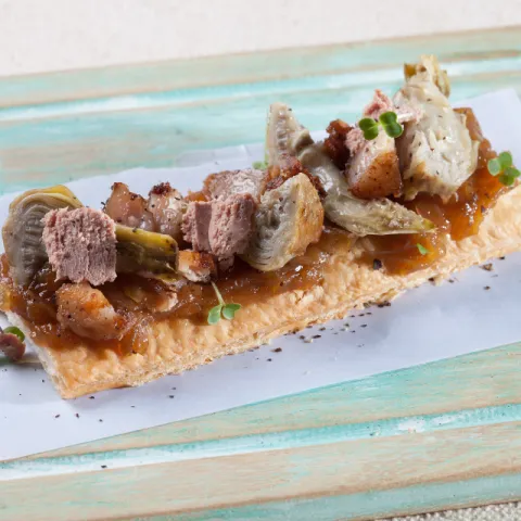 Coca sin gluten con alcachofa, cebolla caramelizada, panceta confitada y mousse de foie-gras.