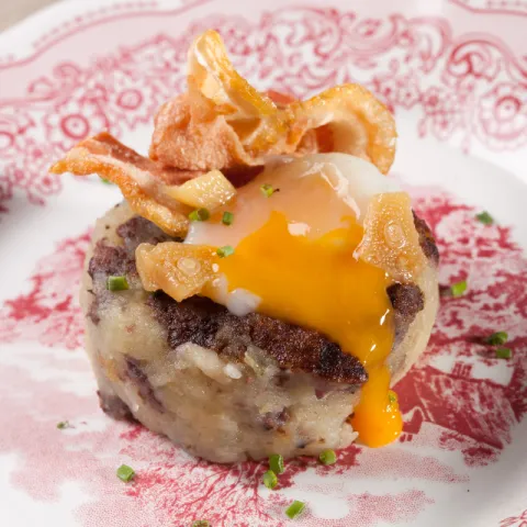 Timbal de patata emmascarada con huevo cocinado a baja temperatura y panceta de cerdo.