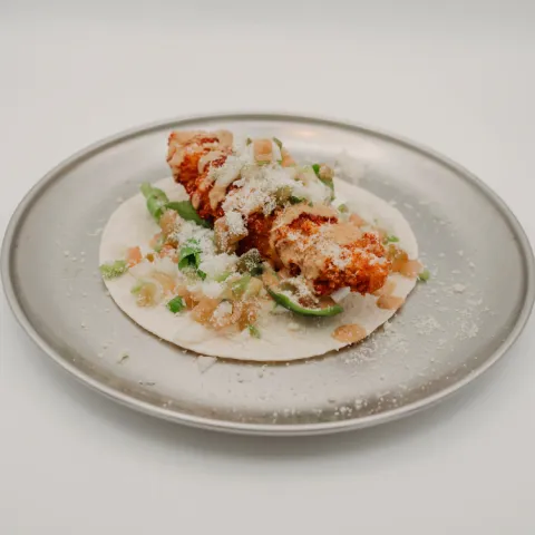 Zona C. Cuando todos los ingredientes encuentran su momento perfecto, ocurre la magia. Un taco de pollo crujiente en panko con crema, queso, rúcula, pico de gallo, parmesano y mayonesa de soja, una combinación de contrastes que lleva el sabor hasta el punto más alto: el auténtico éxtasis.