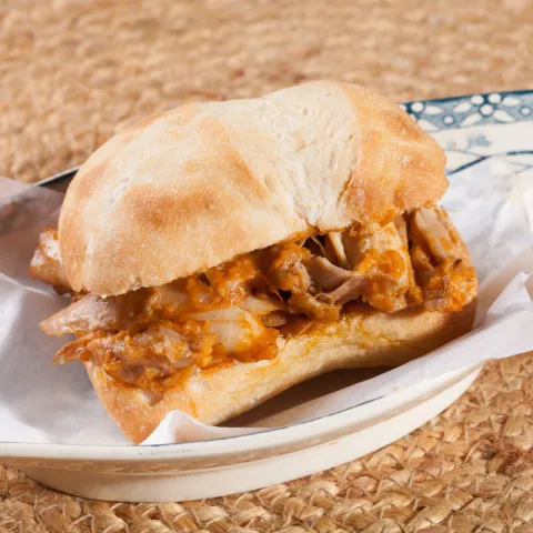 Bocadillo de pollo asado regado con la bresa de tomate, zanahoria, ajos y cebolla.