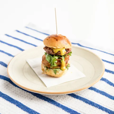 Tapa Pota Blava. Brioche a la plancha de la Montserratina con Pota Blava y patata de Olot, queso de cabra, confitura de cebolla, tomate y lechuga del Parque Agrario.
