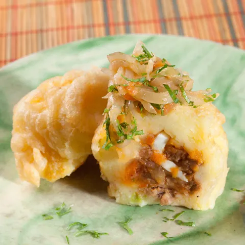 Patata farcida de sofregit de carn de vedella i verdures, ou dur i salsa casolana d'avellanes i vermut