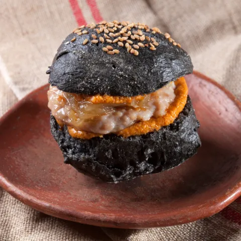 Pan de chapata negro sin gluten, hamburguesa de pollo con avellanas DOP Reus y AOVE DOP Siurana.